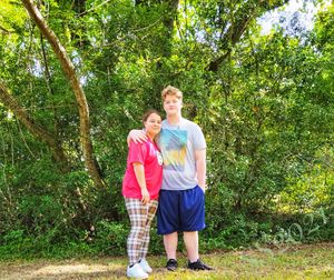 Full length of a boy standing against trees