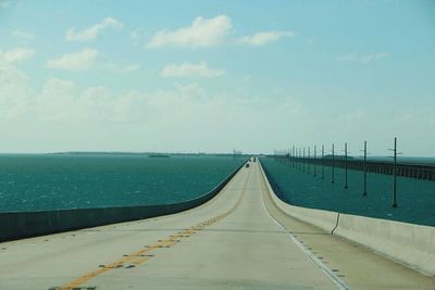 Road by sea against sky