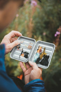 Close-up of man holding fishing baits