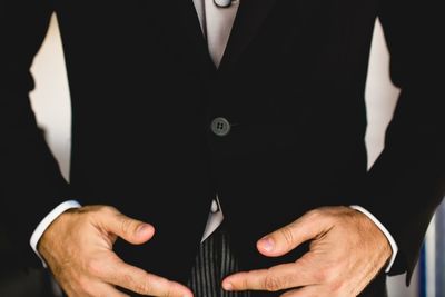 Midsection of groom standing at home