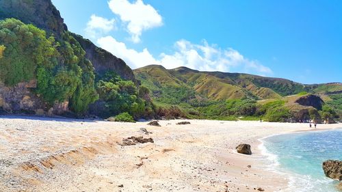 Scenic view of beach and mountains against sky