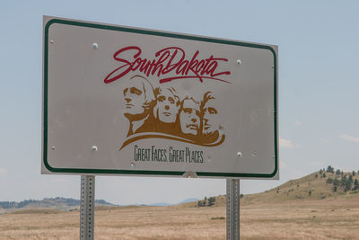 Close-up of road sign against sky