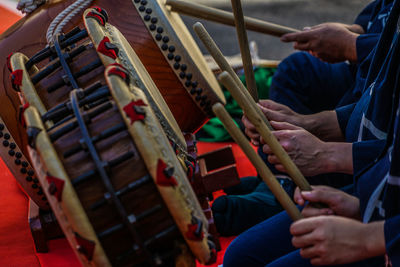 Midsection of man playing drum