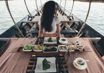 Woman standing by food on table in boat