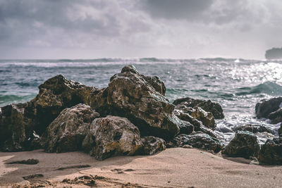 Rocks on beach against sky