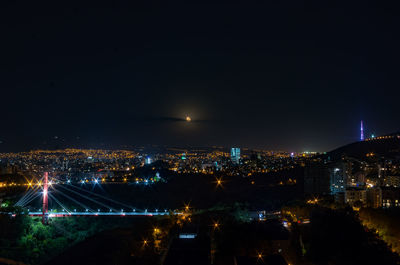 High angle view of illuminated buildings against sky at night