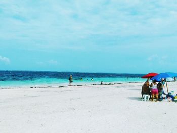 People at beach against sky