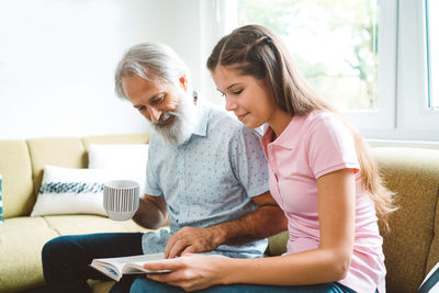 Side view of young woman using laptop at home