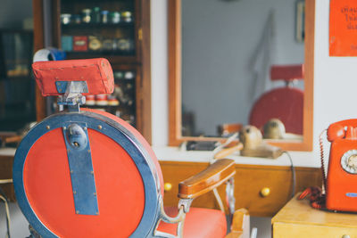 Close-up of chair in front of mirror at barber shop