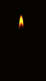 Burning candle in dark room