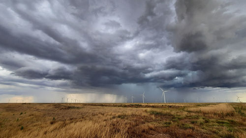 Scenic view of field against cloudy sky