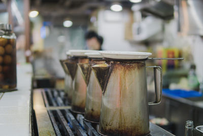 Close-up of jugs on table in kitchen