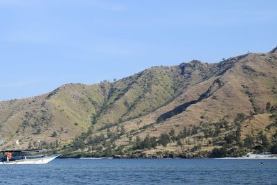 Scenic view of sea and mountains against clear sky