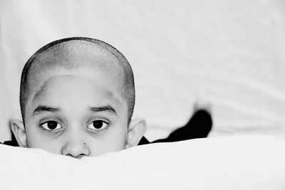 Portrait of cute boy lying on bed at home