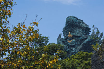 Low angle view of statue against trees