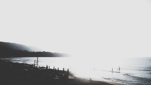 Silhouette people on beach against sky