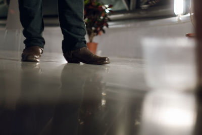 Low section of man standing on tiled floor