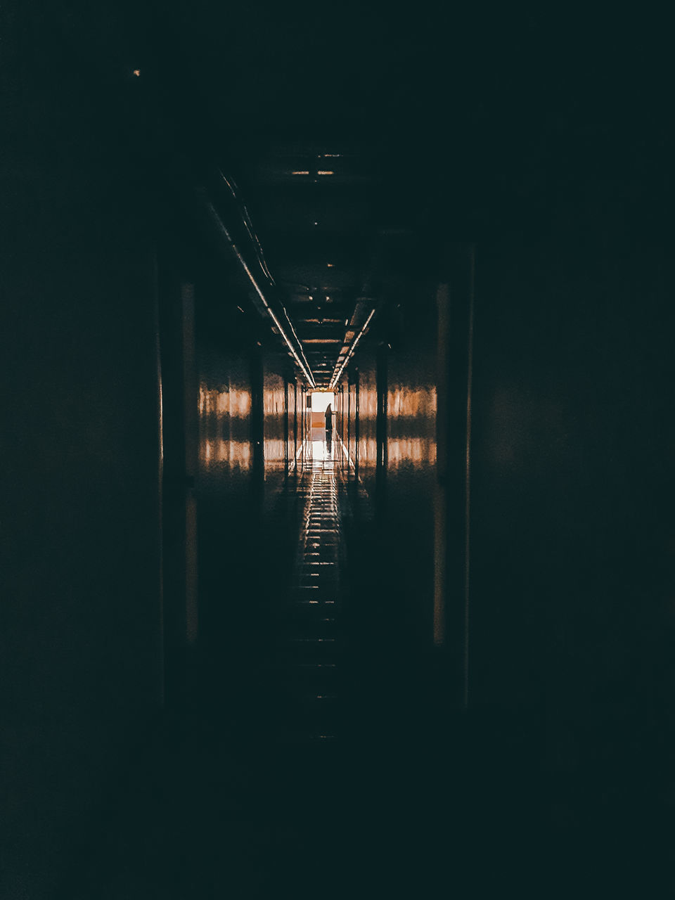 LOW ANGLE VIEW OF ILLUMINATED LIGHTS IN DARK TUNNEL