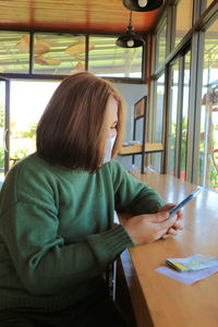 Woman sitting on table in window