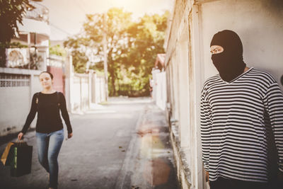 Rear view of man and woman walking in city