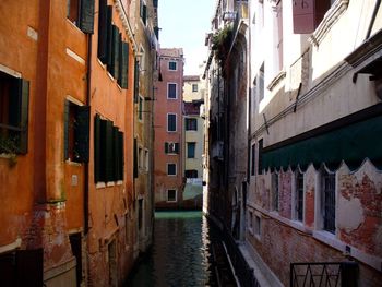 Canal in city against sky