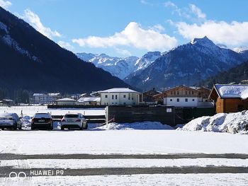 Road by snowcapped mountains against sky