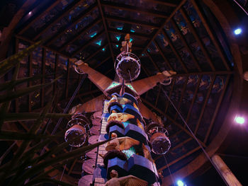Low angle view of illuminated lighting equipment hanging on ceiling