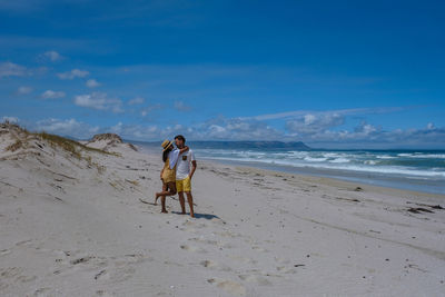 Full length of couple standing on beach