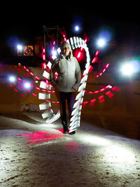 Woman in illuminated city at night