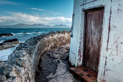 View of old building by sea against sky