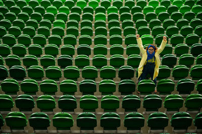 Woman cheers for a sports team at the stadium. the girl watches the match at the stadium alone.