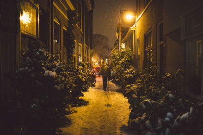 Rear view of man walking amidst buildings