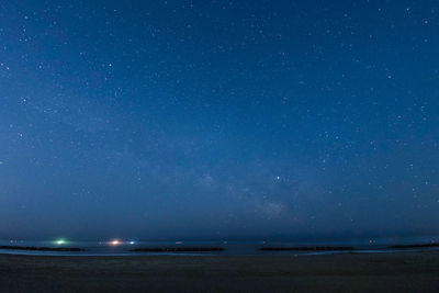Scenic view of sea against star field at night