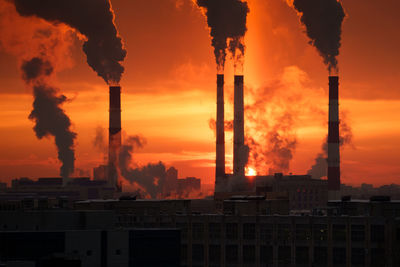 Air pollution and global warming. smoking chimneys of thermal power plant at sunset in winter city