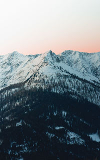Scenic view of snowcapped mountains against clear sky during winter