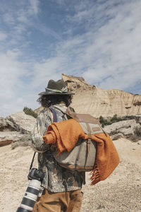 Rear view of a traveler photographer with a backpack in the bardenas desert. navarre