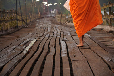 Low section of monk walking on boardwalk