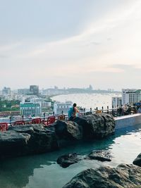 Scenic view of sea by buildings against sky