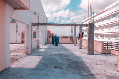 Rear view of people walking on road along buildings