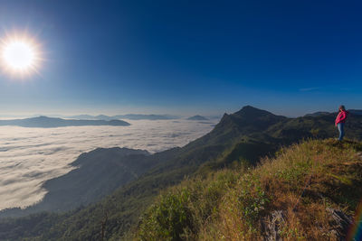 Woman standing on mountains against sky