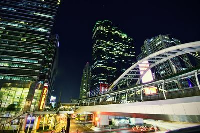 Low angle view of illuminated buildings against sky at night