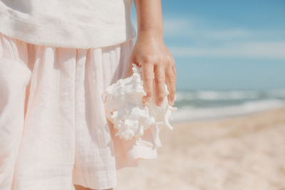 Midsection of woman standing on beach