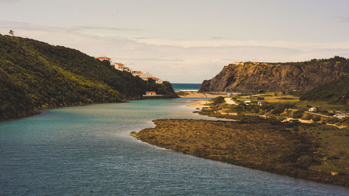 Scenic view of sea and mountains against sky