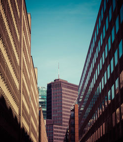 Low angle view of modern buildings against clear blue sky