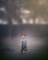 Full length of cute boy standing on land in forest