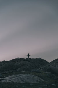 Silhouette man standing on mountain against sky
