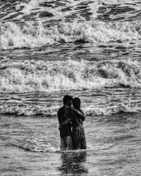 Couple embracing while standing in sea