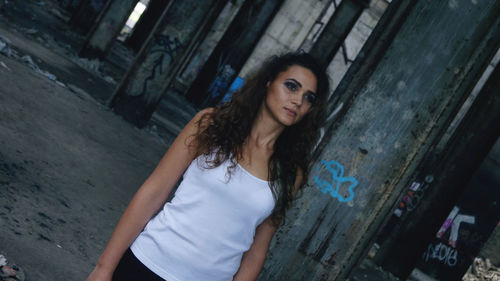 Confident young woman looking away while standing outdoors