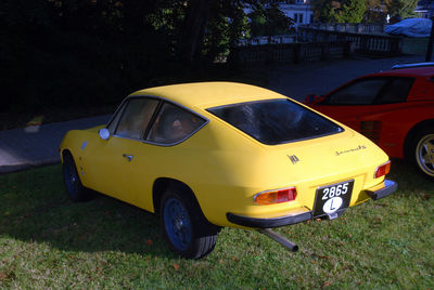 Yellow car parked on street in city