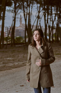 Woman wearing coat standing on road